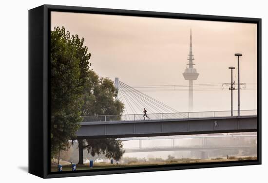 Mannheim, Baden-Württemberg, GER: Male Running Over Bridge Crossing River Neckar On Foggy Morning-Axel Brunst-Framed Premier Image Canvas