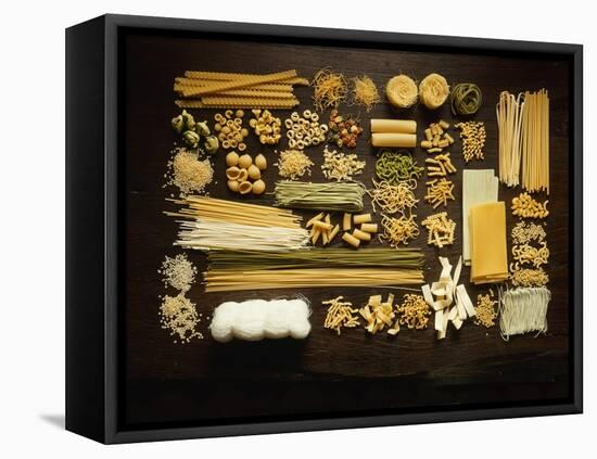 Many Different Types of Pasta on Dark Wooden Background-Walter Cimbal-Framed Premier Image Canvas