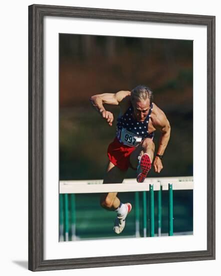 Mature Athlete Competing in Hurdles Race, Atlanta, Georgia, USA-Paul Sutton-Framed Photographic Print