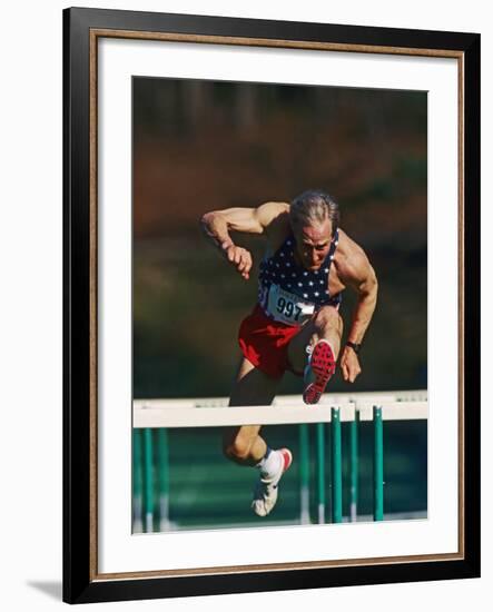 Mature Athlete Competing in Hurdles Race, Atlanta, Georgia, USA-Paul Sutton-Framed Photographic Print