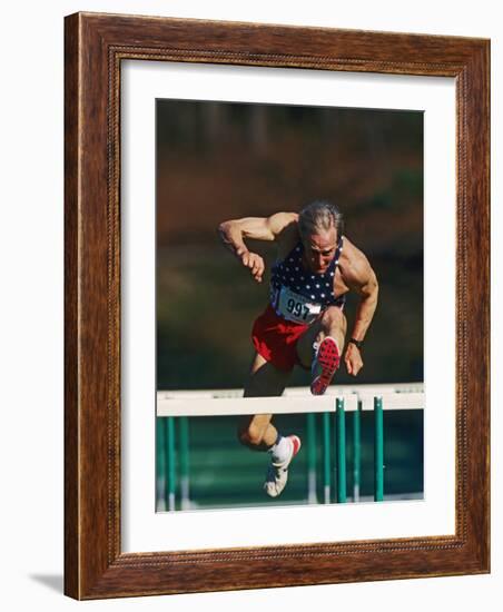 Mature Athlete Competing in Hurdles Race, Atlanta, Georgia, USA-Paul Sutton-Framed Photographic Print