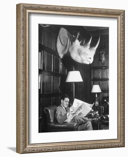 Member Reading Newspaper in Smoking Room at the Harvard Club Beneath a Rhino Head Trophy-Alfred Eisenstaedt-Framed Photographic Print