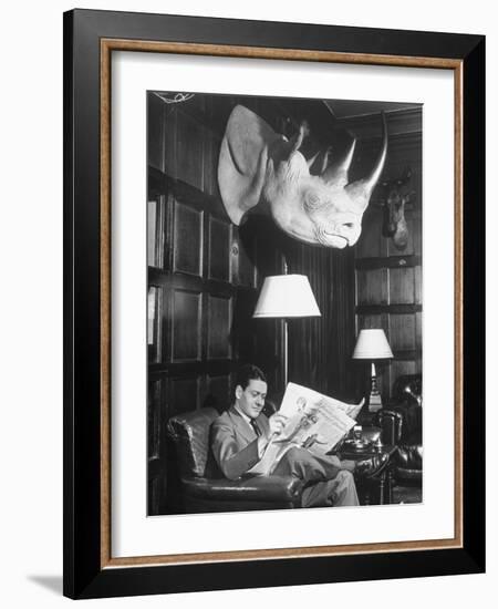 Member Reading Newspaper in Smoking Room at the Harvard Club Beneath a Rhino Head Trophy-Alfred Eisenstaedt-Framed Photographic Print