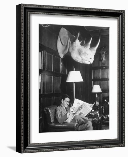 Member Reading Newspaper in Smoking Room at the Harvard Club Beneath a Rhino Head Trophy-Alfred Eisenstaedt-Framed Photographic Print