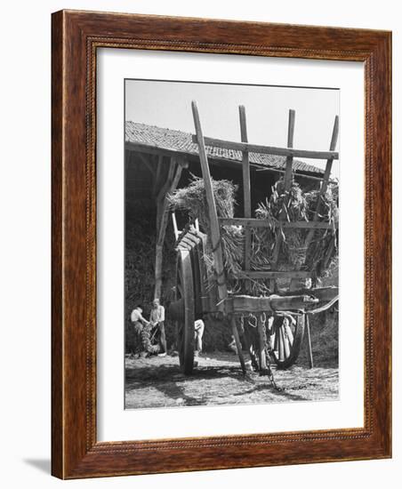 Men Constructing a Wheat Wreath Behind a Wheat Filled Wagon During the Harvest Season-Hans Wild-Framed Photographic Print