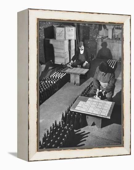 Men Putting Labels on Wine Bottles-Ralph Morse-Framed Premier Image Canvas