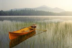 An Adirondack Guide Boat in a Calm Lake with Whiteface Mountain in the Background by Michael Melford