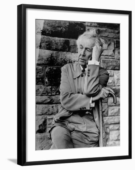 Midwestern Architect Frank Lloyd Wright sits against stone wall-Eliot Elisofon-Framed Premium Photographic Print