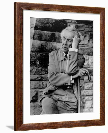 Midwestern Architect Frank Lloyd Wright sits against stone wall-Eliot Elisofon-Framed Premium Photographic Print