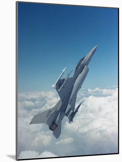 Missile-Armed Us F-16 Fighter Aircraft in Flight, Climbing Above Clouds-null-Mounted Photographic Print