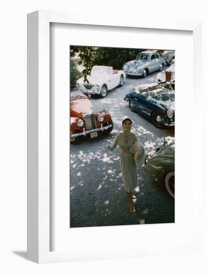 Model in a Dress and Gloves, a Fur over One Arm, and Surrounded by Vintage and Luxury Cars, 1954-Nina Leen-Framed Photographic Print