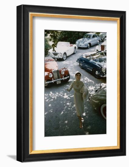 Model in a Dress and Gloves, a Fur over One Arm, and Surrounded by Vintage and Luxury Cars, 1954-Nina Leen-Framed Photographic Print