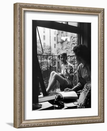 Model Jean Patchet Seated on a Fire Escape, Talks with Eileen Ford, New York, NY, 1948-Nina Leen-Framed Photographic Print