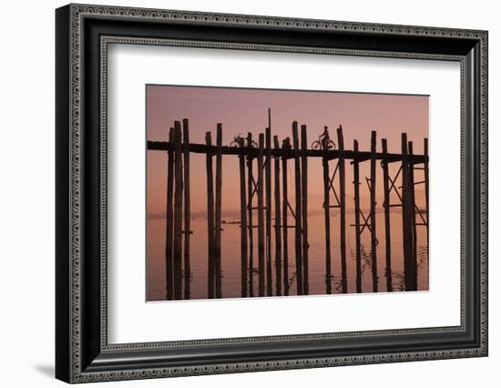 Monk walking at sunrise over the lake near wooden footbridge. Taungthaman Lake, Myanmar.-Michele Niles-Framed Photographic Print