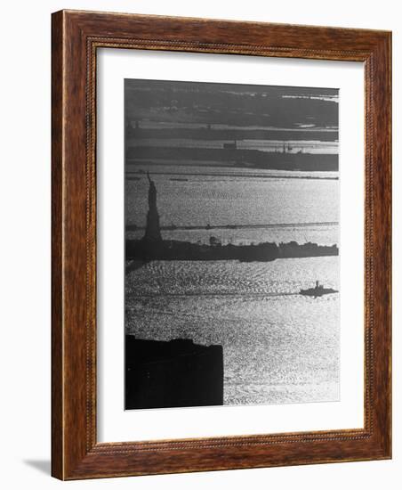 Moonlight on the Waters Surrounding Statue of Liberty as a Tug Boat Steams Past in New York Harbor-Andreas Feininger-Framed Photographic Print