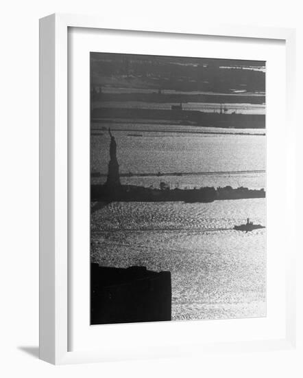 Moonlight on the Waters Surrounding Statue of Liberty as a Tug Boat Steams Past in New York Harbor-Andreas Feininger-Framed Photographic Print