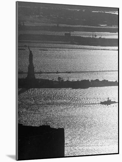 Moonlight on the Waters Surrounding Statue of Liberty as a Tug Boat Steams Past in New York Harbor-Andreas Feininger-Mounted Photographic Print