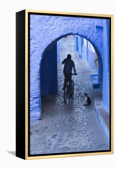 Morocco, Chefchaouen. Bicyclist Rides Past Cat in Archway in the Blue Village of Chefchaouen-Brenda Tharp-Framed Premier Image Canvas