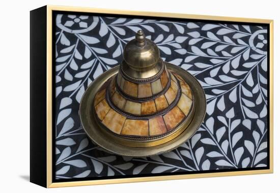 Morocco, Fes. A covered brass bowl with inlay of camel bone sites on a stone inlay table in a shop.-Brenda Tharp-Framed Premier Image Canvas