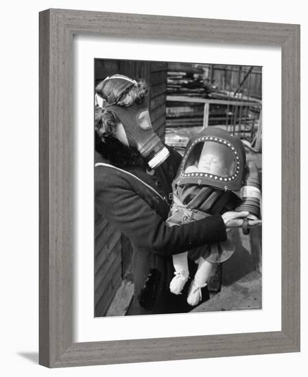 Mother and Baby Wearing Gas Masks During Gas Preparations Test During WWII-Hans Wild-Framed Photographic Print