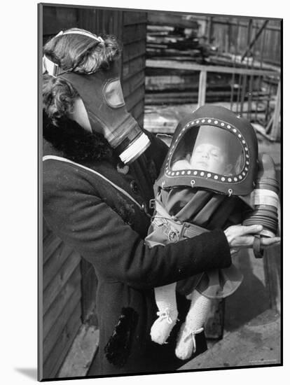 Mother and Baby Wearing Gas Masks During Gas Preparations Test During WWII-Hans Wild-Mounted Photographic Print