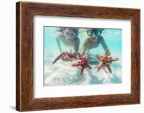 Mother and son with scuba masks showing red starfish underwater, Zanzibar, Tanzania-Roberto Moiola-Framed Photographic Print