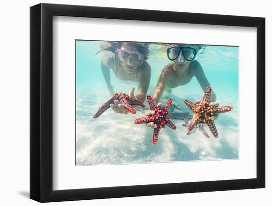 Mother and son with scuba masks showing red starfish underwater, Zanzibar, Tanzania-Roberto Moiola-Framed Photographic Print