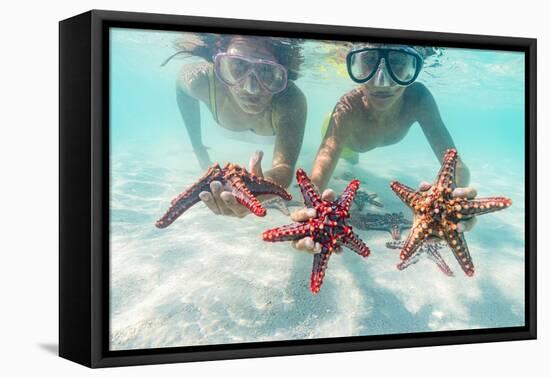 Mother and son with scuba masks showing red starfish underwater, Zanzibar, Tanzania-Roberto Moiola-Framed Premier Image Canvas