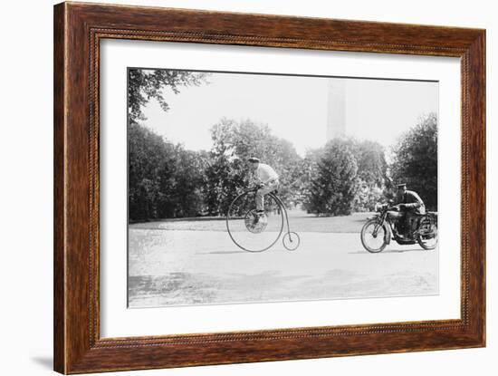 Motorcycle Cop Chases a Penny Farthing Velocipede Down a DC Street with Washington Monument in Back-null-Framed Art Print