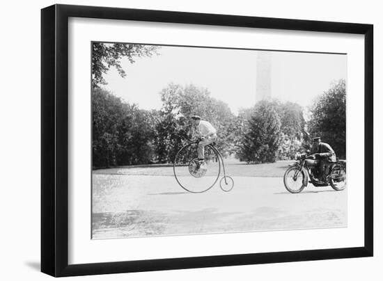 Motorcycle Cop Chases a Penny Farthing Velocipede Down a DC Street with Washington Monument in Back-null-Framed Art Print