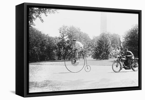 Motorcycle Cop Chases a Penny Farthing Velocipede Down a DC Street with Washington Monument in Back-null-Framed Stretched Canvas