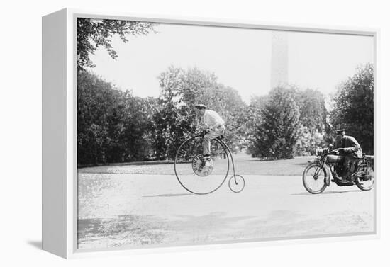 Motorcycle Cop Chases a Penny Farthing Velocipede Down a DC Street with Washington Monument in Back-null-Framed Stretched Canvas