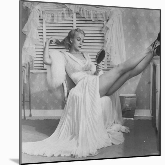 Movie Actress Carole Landis in Negligee as she Brushes Her Hair, Showing Off Gorgeous Legs-Peter Stackpole-Mounted Premium Photographic Print