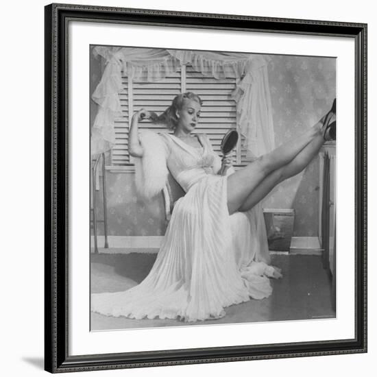 Movie Actress Carole Landis in Negligee as she Brushes Her Hair, Showing Off Gorgeous Legs-Peter Stackpole-Framed Premium Photographic Print