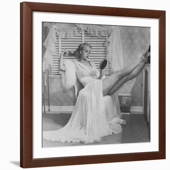 Movie Actress Carole Landis in Negligee as she Brushes Her Hair, Showing Off Gorgeous Legs-Peter Stackpole-Framed Premium Photographic Print