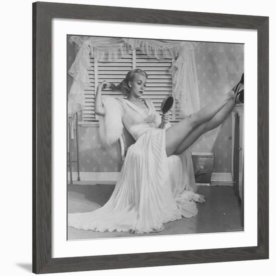 Movie Actress Carole Landis in Negligee as she Brushes Her Hair, Showing Off Gorgeous Legs-Peter Stackpole-Framed Premium Photographic Print