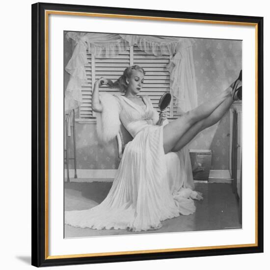 Movie Actress Carole Landis in Negligee as she Brushes Her Hair, Showing Off Gorgeous Legs-Peter Stackpole-Framed Premium Photographic Print