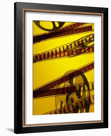 Movie Film and Reel in Yellow Light-null-Framed Photographic Print