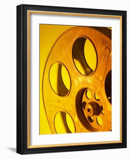 Movie Film and Reels in Yellow Light-null-Framed Photographic Print