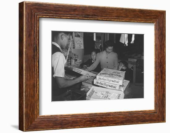 Mrs. Yaeko Nakamura shows her daughters jigsaw puzzles in a store at Manzanar, 1943-Ansel Adams-Framed Photographic Print