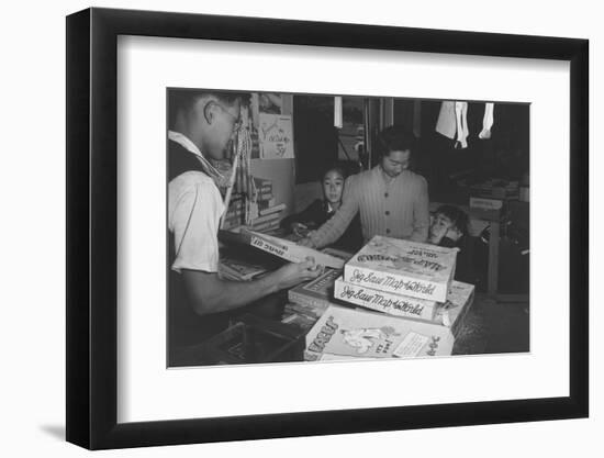 Mrs. Yaeko Nakamura shows her daughters jigsaw puzzles in a store at Manzanar, 1943-Ansel Adams-Framed Photographic Print