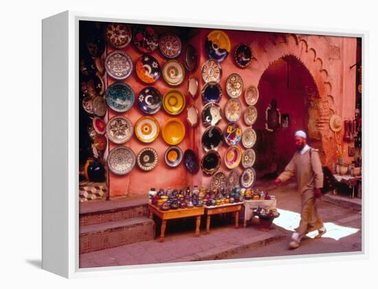 Muslim Man Walks by Wall of Moroccan Pottery, Marrakech, Morocco-John & Lisa Merrill-Framed Premier Image Canvas