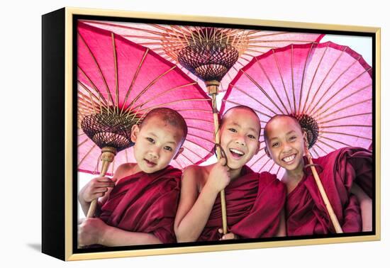 Myanmar, Mandalay Division, Bagan. Portrait of Three Novice Monks under Red Umbrellas (Mr)-Matteo Colombo-Framed Premier Image Canvas