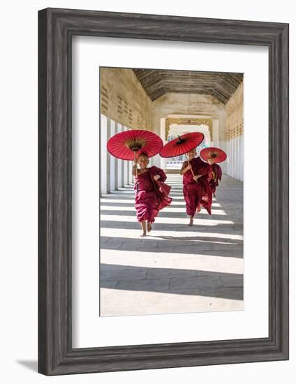 Myanmar, Mandalay Division, Bagan. Three Novice Monks Running with Red Umbrellas in a Walkway (Mr)-Matteo Colombo-Framed Photographic Print