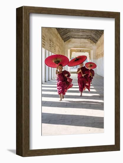 Myanmar, Mandalay Division, Bagan. Three Novice Monks Running with Red Umbrellas in a Walkway (Mr)-Matteo Colombo-Framed Photographic Print