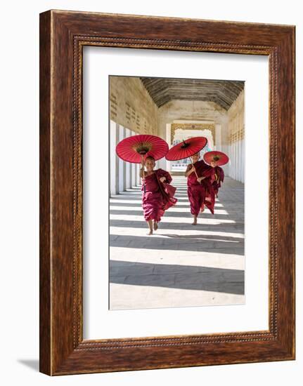 Myanmar, Mandalay Division, Bagan. Three Novice Monks Running with Red Umbrellas in a Walkway (Mr)-Matteo Colombo-Framed Photographic Print