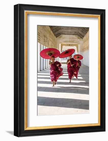 Myanmar, Mandalay Division, Bagan. Three Novice Monks Running with Red Umbrellas in a Walkway (Mr)-Matteo Colombo-Framed Photographic Print