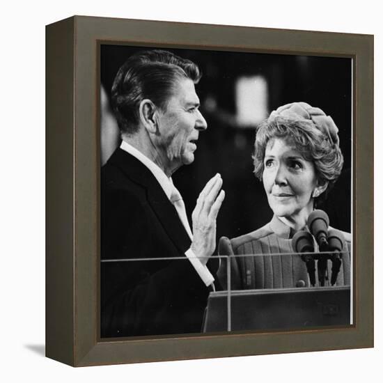 Nancy Reagan Proudly Watches as Her Husband Ronald Reagan Takes the Oath of Office-null-Framed Premier Image Canvas