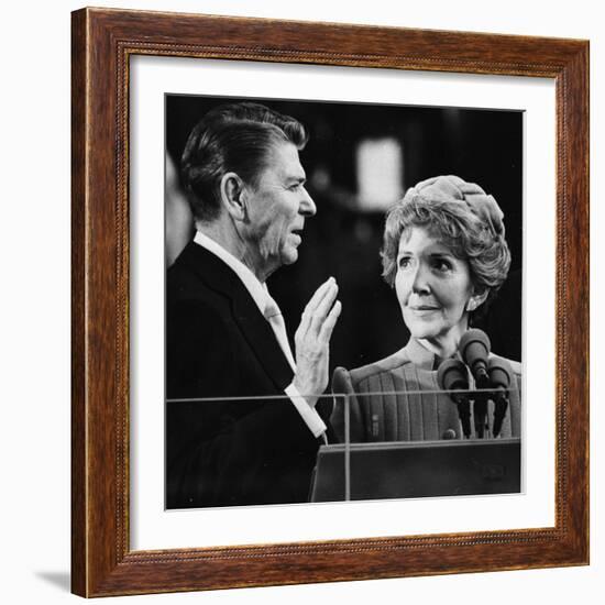 Nancy Reagan Proudly Watches as Her Husband Ronald Reagan Takes the Oath of Office-null-Framed Photographic Print