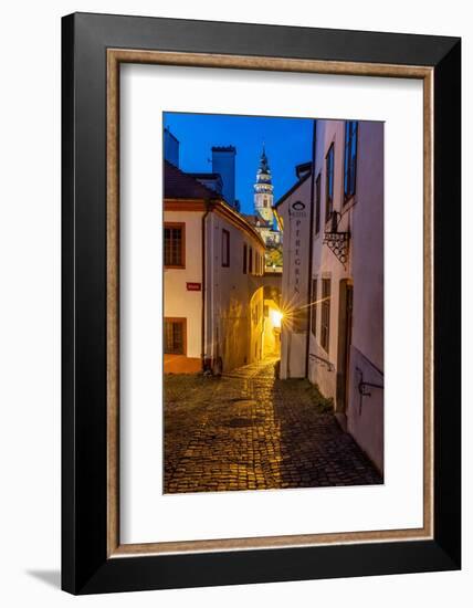 Narrow cobblestone streets at dusk with Castle Tower in historic Cesky Krumlov, Czech Republic.-Chuck Haney-Framed Photographic Print